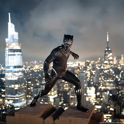 Black Panther wax figure on NYC rooftop with city skyline at night.